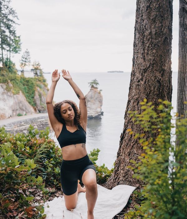 Woman performing a calm yoga pose in a dark, serene environment.